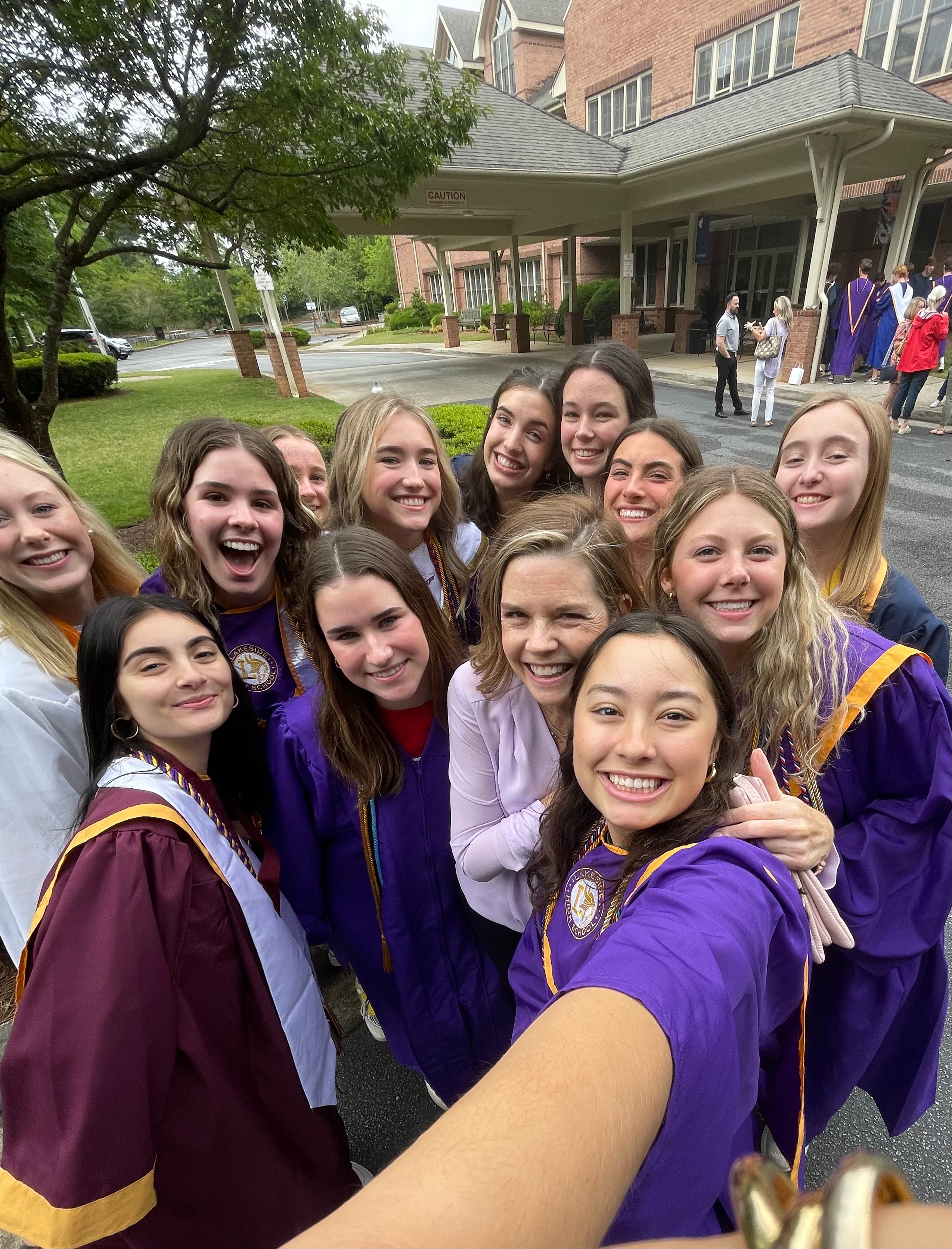 Teacher smiling with students graduating